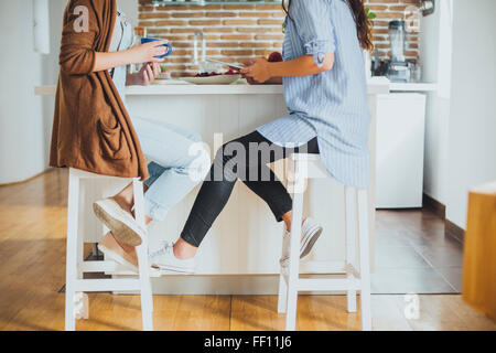 Les femmes de race blanche assis au comptoir Banque D'Images