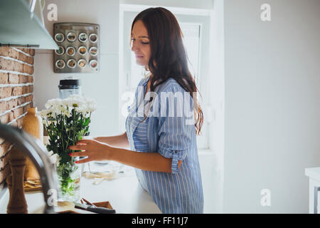 Caucasian woman arranging flowers Banque D'Images