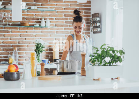 Caucasian woman cooking in kitchen Banque D'Images