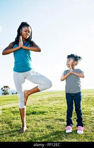 Black mother and daughter practicing yoga Banque D'Images