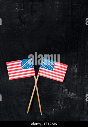 Deux drapeaux en papier pour la décoration de la pâtisserie sur fond de bois noir Banque D'Images