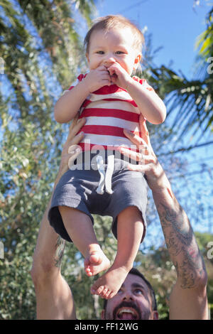 Mixed Race woman holding baby outdoors Banque D'Images