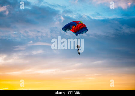 Parachutiste sur parachute coloré coucher de soleil lever du soleil Ciel. Passe-temps actif Banque D'Images