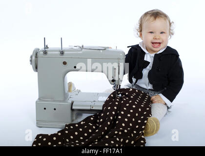 Photo de petite fille avec machine à coudre Banque D'Images