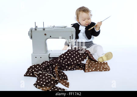 Photo de petite fille avec machine à coudre Banque D'Images