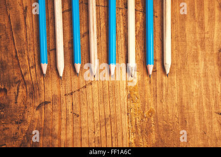 Bleu et marron crayons alignés sur une table en bois rustique, vue supérieure avec copie espace vierge Banque D'Images