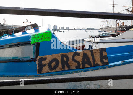 Close-up d'une petite vieille cabin cruiser en fibre de verre avec un 'à vendre' inscription peinte sur une carte. Le port de Portsmouth. Banque D'Images