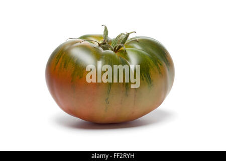 Seul frais entier RAF heirloom tomato sur fond blanc Banque D'Images