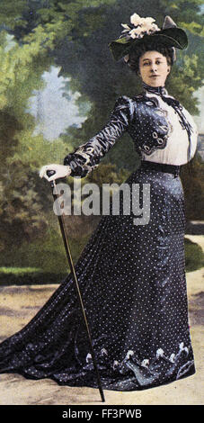 EDWARDIAN FASHION vers 1905 Carte postale montrant la petite taille à la mode alors en arrière et jupe de balayage combiné avec une canne garnie d'argent Banque D'Images