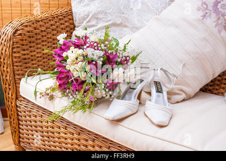 Chaussures de mariée et de fleurs sur le canapé pour se préparer Banque D'Images