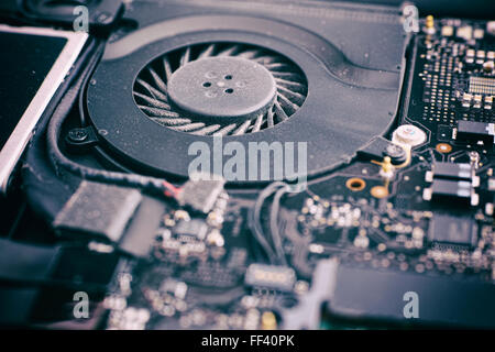 Ventilateur pour ordinateur portable avec de la poussière en elle et de la carte système. L'accent est sur le ventilateur. Close up. Banque D'Images