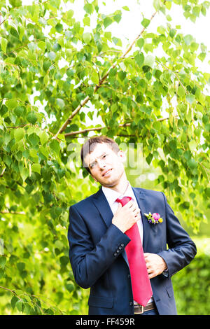 Beau palefrenier à tuxedo mariage souriant et en attente d'épouse. Happy smiling young groom. Riche mariés à jour du mariage. Marié en costume élégant smoking. Handsome young man in tuxedo Banque D'Images