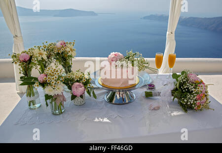 Gâteau de mariage et des bouquets de fleurs sur la table, contre la mer. La Grèce. Banque D'Images