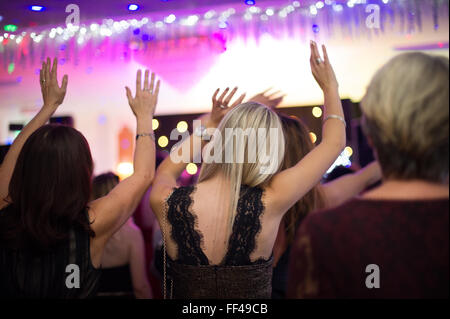 Soirée entre filles à partie de la musique de danse en agitant les bras en l'air Banque D'Images