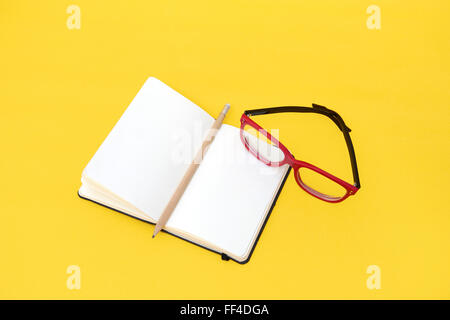 Ordinateur portable lunettes et isolé sur fond jaune Banque D'Images