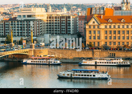 PRAGUE, RÉPUBLIQUE TCHÈQUE - le 9 octobre 2014 : les bateaux de croisière naviguant sur la rivière Vltava. Heure du coucher de soleil. Banque D'Images