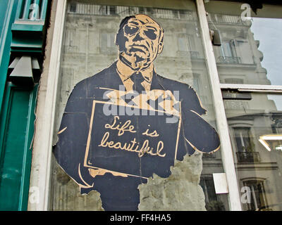 Peinture murale par M. Brainwash MBW à Paris montrant un homme tenant un clap disant la vie est belle sur une vitrine Banque D'Images