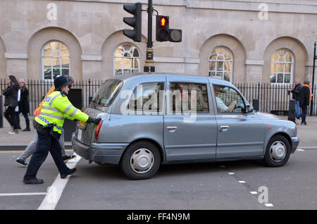 Londres, Royaume-Uni, 10 février 2016, un taxi tombe en panne pendant la manifestation et est poussé vers le bord de la route par la police. Environ 8000 cabs a bloqué la route de Trafalgar Square et de Whitehall, Westminster Bridge pour protester contre l'application Uber et CFF l'émission de licences de mini-cab. Credit : JOHNNY ARMSTEAD/Alamy Live News Banque D'Images
