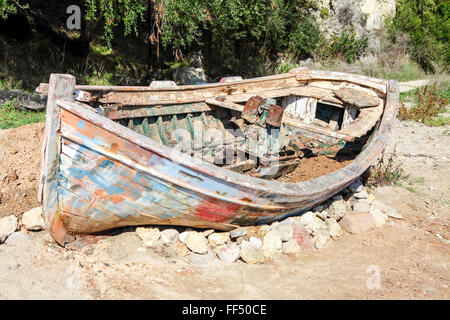 Bateau de pêcheur traditionnel grec pourrit lentement à l'écart par négligence sur la plage de Valtos en Grèce. Banque D'Images