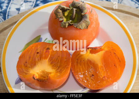 Tranches de persimmon frais et biologiques sur le plat blanc Banque D'Images