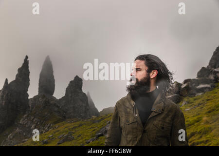 Un homme debout avec un fond de rock de coraux sur la ligne d'horizon, un paysage balayé par spectaculaire et de nuages bas. Banque D'Images