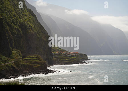 Une étroite route serpente le long des falaises, des chaînes de montagne et les villages isolés près de Ponta Delgada, côte nord de Madère Banque D'Images