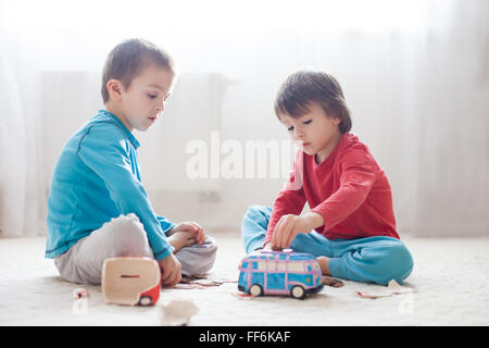 Petits enfants, garçons, brisant leur tirelire, vidant tous les économisé de l'argent pour acheter des cadeaux pour la fête des mères Banque D'Images