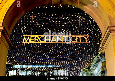 Le Merchant City sign in Royal Exchange Square, Glasgow city centre, éclairé la nuit contre une toile de scintillement. Banque D'Images