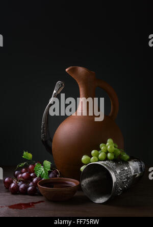 Coupe de vin de raisins et de l'avertisseur sonore potable cruche sur une table en bois Banque D'Images