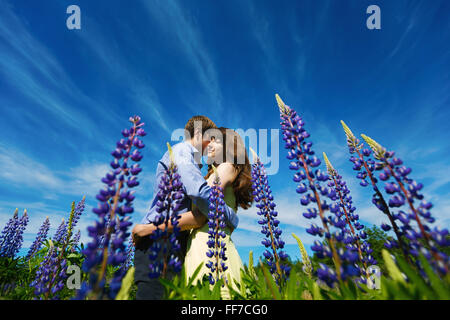 En couple et faire place au champ de fleurs de lupin smiling Banque D'Images