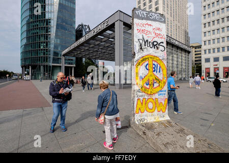 Les touristes avec des sections de mur de Berlin qui ont été installés dans la Potsdamer Platz, Berlin, Allemagne. Banque D'Images