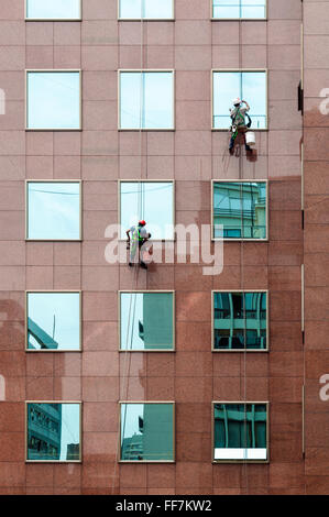 Deux laveurs de vitres au travail et de bâtiment de bureaux Banque D'Images