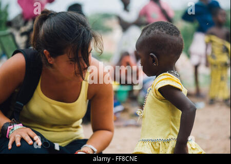 Mali, Afrique - Young caucasian woman bénévoles ayant du plaisir à jouer et danser avec un bébé femelle noire près de Bamako Banque D'Images