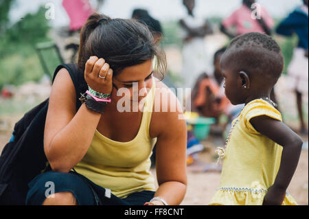 Mali, Afrique - Young caucasian woman bénévoles ayant du plaisir à jouer et danser avec un bébé femelle noire près de Bamako Banque D'Images