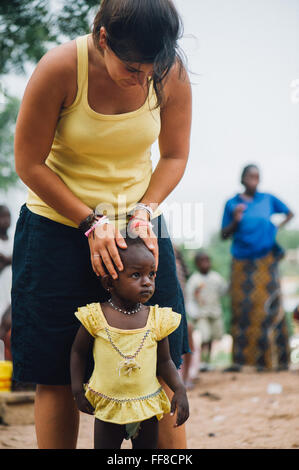 Mali, Afrique - Young caucasian woman bénévoles ayant du plaisir à jouer et danser avec un bébé femelle noire près de Bamako Banque D'Images