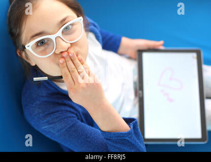 Premier amour, fille dessine un coeur. Je vous aime .... Enfant jouant avec tablet Banque D'Images