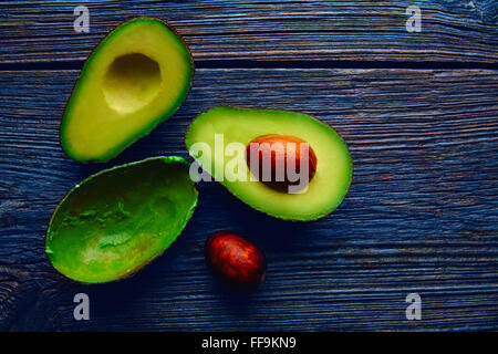 Couper l'avocat sur le bois de chauffage coupé la moitié du tableau Banque D'Images