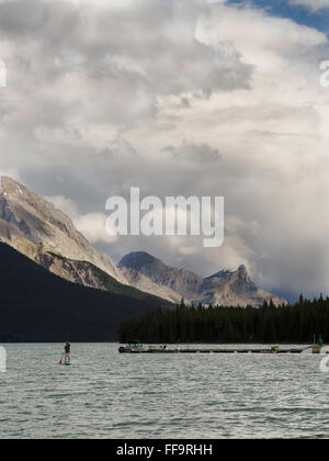 Un stand-up paddleboarder fait son chemin à travers le lac Maligne sur l'image. Le Parc National de Jasper, Jasper, Alberta, Canada. Banque D'Images