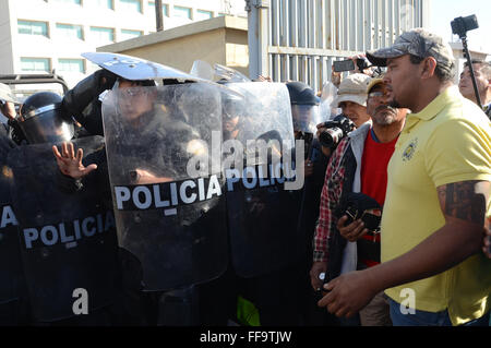 Monterrey, Mexique. Feb 11, 2016. Les membres de la famille des détenus affirment avec éléments de sécurité qu'ils attendent pour l'information à l'extérieur de la prison, Topo Chico à Monterrey, dans l'État de Nuevo Leon, Mexique, le 11 février, 2016. Jaime Rodriguez Calderon, Gouverneur de Nuevo Leon, au courant d'une conférence de presse que 52 personnes ont été tuées et 12 blessées après une bagarre a éclaté entre deux fractions rivales des détenus à l'intérieur de la prison Topo Chico. © ABC/Xinhua/Alamy Live News Banque D'Images