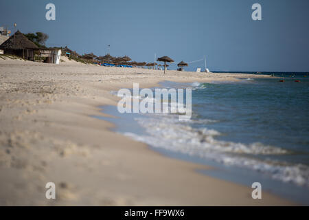 Matin voir d'une plage en Tunisie, bord de l'eau en premier plan, parasols et chaises loin dans la distance Banque D'Images