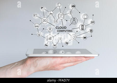 Le cloud computing et l'informatique mobile concept. Main tenant une tablette ou un téléphone intelligent. Réseau cloud d'appareils connectés Banque D'Images