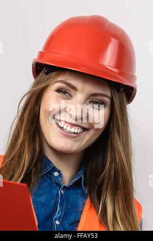 Woman construction worker builder engineerin structurels en gilet orange casque dur rouge. La sécurité dans le travail industriel. Studio shot Banque D'Images