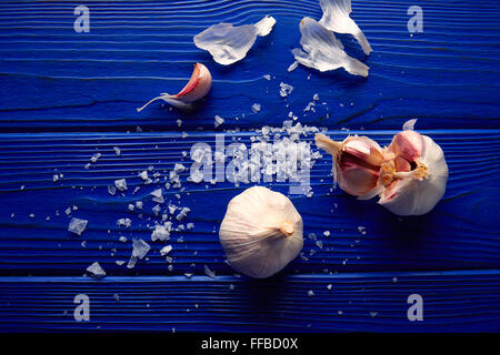 L'ail et le sel répandu sur une table en bois bleu avec composition occasionnels Banque D'Images