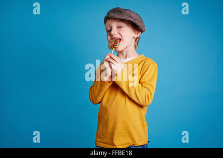 Happy boy en léchant casualwear sucre candi Banque D'Images