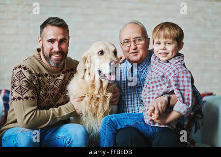 Homme mûr, jeune homme, petit garçon et pet looking at camera Banque D'Images