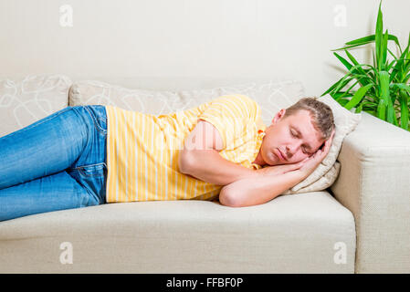 Fatigué de donner pour faire une sieste sur le canapé dans le salon Banque D'Images