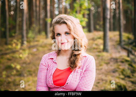 Close Up belle grande taille Young Smiling Woman in shirt posant dans la forêt d'été Banque D'Images