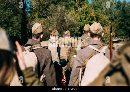 Groupe d'interprètes historiques non identifiés habillés en soldats russe soviétique va le long d'une route forestière. Banque D'Images