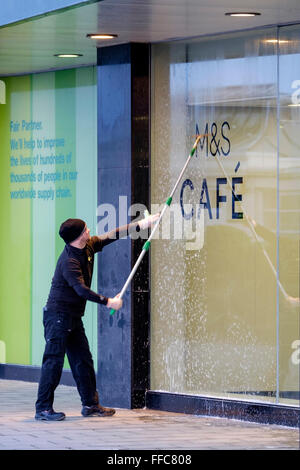 Une vitrine en cours de nettoyage à Worthing, UK, 12/02/2016 : une fenêtre de travail plus propre sur une vitrine de Marks & Spencer. Photo par Julie Edwards Banque D'Images