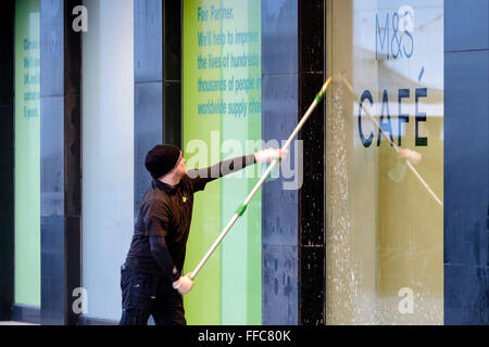 Une vitrine en cours de nettoyage à Worthing, UK, 12/02/2016 : une fenêtre de travail plus propre sur une vitrine de Marks & Spencer. Photo par Julie Edwards Banque D'Images